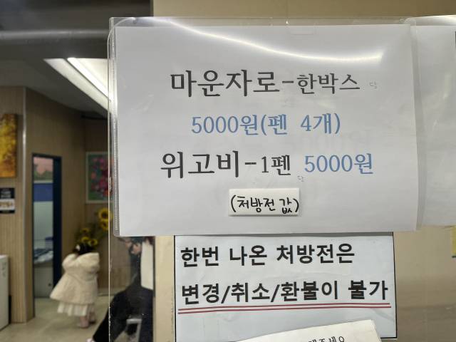 의원 내부에 마운자로와 위고비 처방 가격이 안내돼 있다. 마운자로는 한 박스 기준, 위고비는 1펜 단위로 가격이 공지돼 있으며 ‘처방전 값 별도’라는 문구도 함께 적혀 있다. 신서희 기자