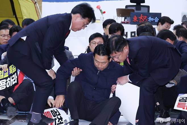 장동혁 국민의힘 대표가 19일 서울 여의도 국회 로텐더홀에서 열린 통일교 게이트·더불어민주당 공천뇌물 특검 촉구 규탄대회를 마친 후 송언석 원내대표 등의 부축을 받고 있다. /사진=뉴스1