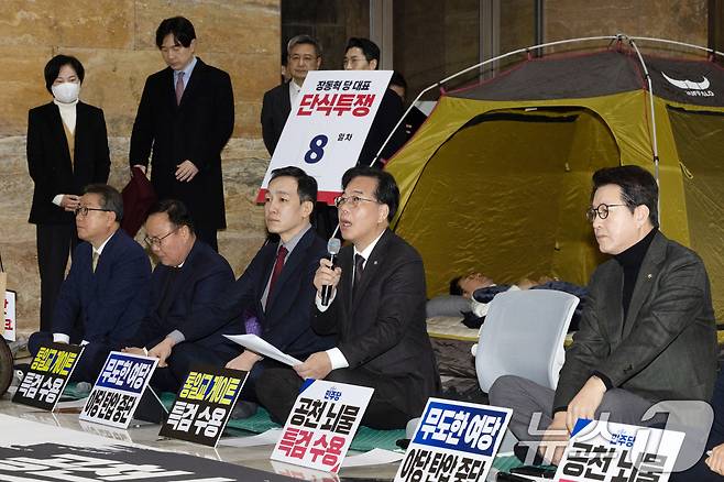 송언석 국민의힘 원내대표가 22일 서울 여의도 국회 로텐더홀에서 열린 최고위원회의에서 모두발언하는 가운데 단식 중인 장동혁 대표가 누워서 휴식을 취하고 있다. 2026.1.22/뉴스1 ⓒ News1 이승배 기자