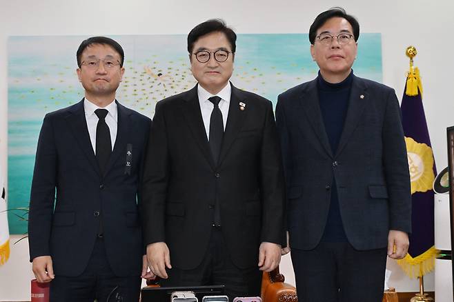 더불어민주당 한병도 원내대표(왼쪽)와 국민의힘 송언석 원내대표(오른쪽)가 27일 국회에서 우원식 국회의장 주재로 열린 여야 원내대표 회동에서 만나 기념 촬영하고 있다. 연합뉴스