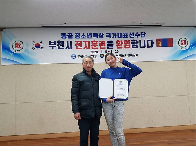 부천시육상연맹 노문선 회장(왼쪽)이 2020년 1월 몽골 육상 유망주 초청 전지훈련을 하면서 당시 멀리뛰기 선수로 방한한 인쿠시와 기념 사진을 찍고 있다. 부천시육상연맹 제공