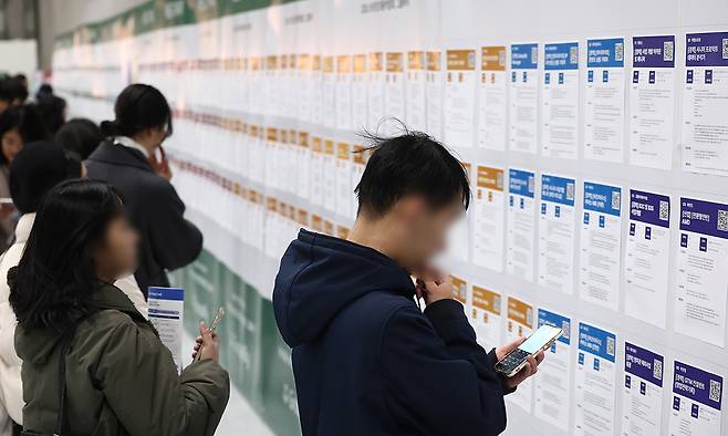 지난 1월 서울 강남구 코엑스에서 열린 '2026 스타트업 채용박람회'를 찾은 구직자들이 채용공고 게시대를 살펴보고 있다. 연합뉴스