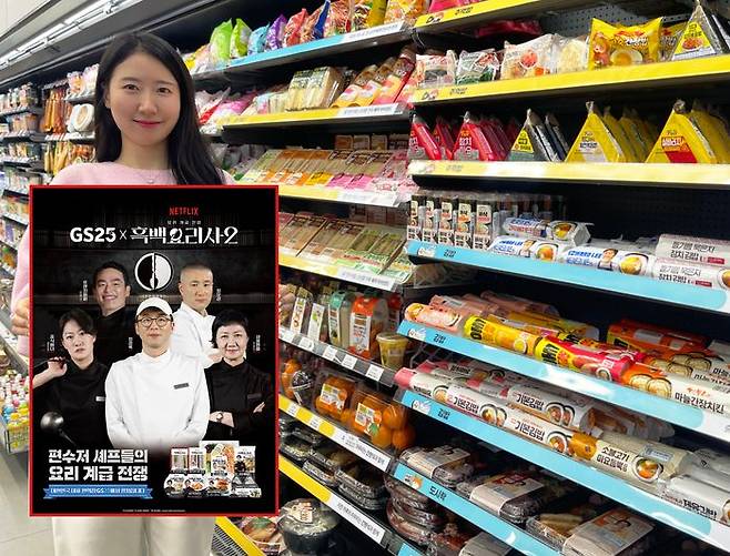 GS25에서 모델이 간편식품 진열대 앞에서 흑백요리사2 컬래버 상품 출시 안내 홍보물을 들고 있다.ⓒGS25