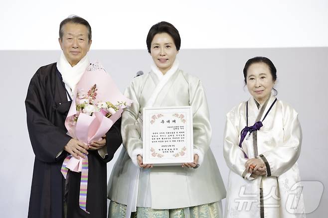 김혜경 여사가 6일 서울 중구 정동1928 아트센터에서 열린 2026 설맞이 한복인 신년회에서 한복 명예홍보대사 추대패를 전달받은 뒤 정순훈 한복세계화재단 이사장, 구혜자 침선장 겸 한복세계화재단 고문과 함께 기념 촬영을 하고 있다. (청와대통신사진기자단) 2026.2.6 / ⓒ 뉴스1 이재명 기자