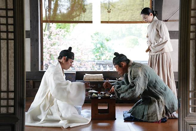 영화 <왕과 사는 남자>에서 왕위에서 쫓겨나고 유배 온 어린 선왕 이홍위(박지훈)와 마을 촌장 엄흥도(유해진)가 밥상을 두고 마주 앉아 있다. 쇼박스 제공