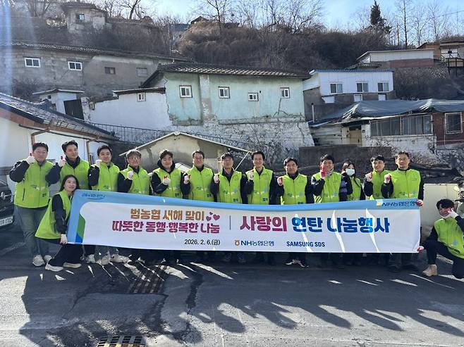 6일 서울 서대문구 일대 연탄 나눔 행사에 참석한 김주식 NH농협은행 AI데이터부문 부행장과 직원들이 삼성SDS 임직원들과 함께 기념 촬영을 하고 있다. NH농협은행 제공