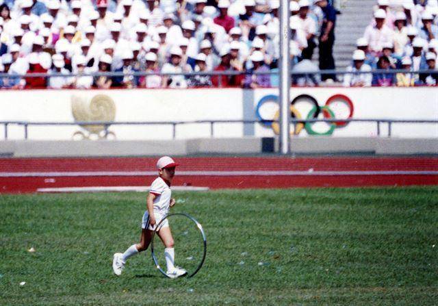 1988년 9월 17일 서울에서 열린 1988 서울올림픽 개막식에 등장한 '굴렁쇠 소년' 윤태웅(당시 7세)군. '삐이-' 비프음이 멈춘 뒤 홀로 굴렁쇠를 굴리며 경기장을 가로지른 이 소년의 모습은 한국전쟁의 폐허 속에서도 움튼 생명과 평화를 상징한다는 평가를 받았다. 한국일보 자료사진