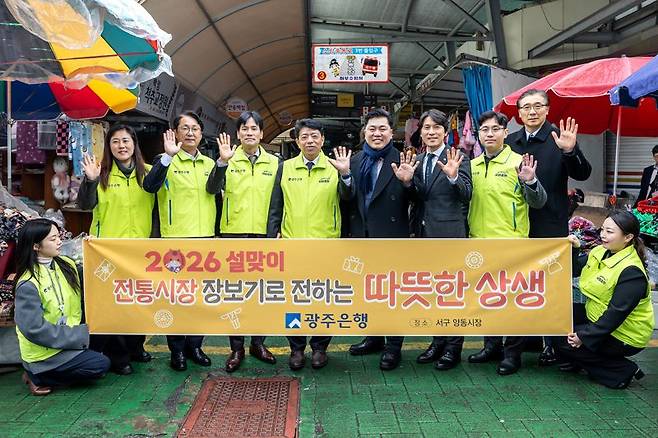 광주은행은 설 명절을 앞두고 10일 광주광역시 서구 양동시장에서 설맞이 전통시장 장보기 행사를 진행했다고 밝혔다. 사진은 (서 있는 사람 기준 왼쪽에서 네 번째부터) 정일선 광주은행장, 전승일 광주광역시 서구의회 의장, 변정근 초록우산 광주지역본부장이 관계자들과 기념촬영을 하고 있는 모습. 광주은행 제공