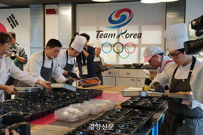 이탈리아 밀라노의 대한체육회 급식 지원센터 직원들이 지난 9일 완성된 음식을 도시락에 담고 있다. 밀라노|이정호기자