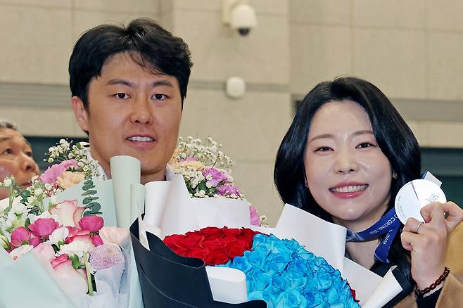2026 밀라노·코르티나담페초 동계올림픽 스노보드 평행대회전 은메달리스트 김상겸(왼쪽)이 10일 인천국제공항을 통해 귀국한 자리에서 아내 박한솔씨와 기념 사진을 촬영하고 있다. 인천공항 | 연합뉴스