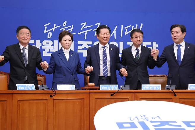 정청래 더불어민주당 대표(가운데)가 11일 서울 여의도 국회에서 열린 최고위원회의에서 민주당 지도부의 손을 잡고 있다. 연합뉴스