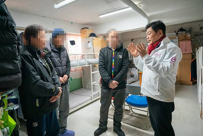 실내에서 이필형 동대문구청장이 고시원 거주민들과 간담회를 하고 있는 사진이다. 이필형 구청장이 밝은 표정으로 두 손을 들어 대화하고 있다.