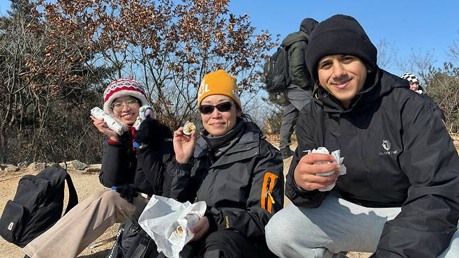 8일 오후 1시쯤 북한산 영봉에서 외국인 관광객들이 김밥과 K팝 아이돌 인형을 들고 포즈를 취하고 있다. 이날 최저기온 영하 15도의 한파 속에 네팔·슬로바키아·필리핀·캐나다·미얀마·호주·인도네시아·파키스탄 등에서 온 외국인 20여 명이 북한산에 올랐다. /최하연 기자