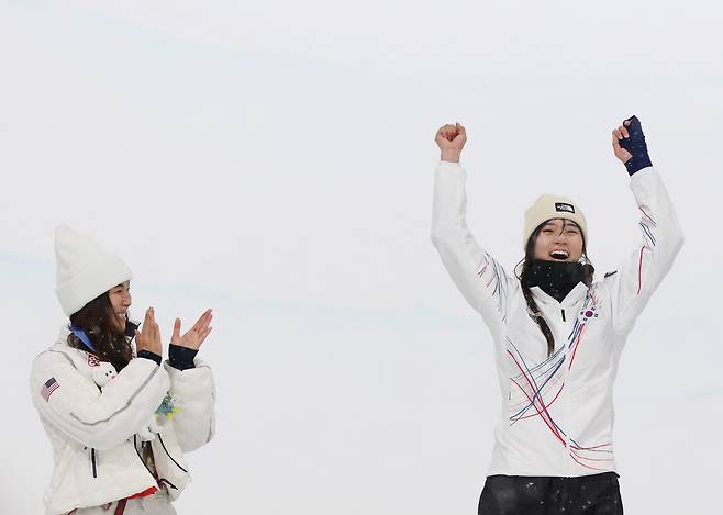 12일(현지시간) 이탈리아 리비뇨 스노파크에서 열린 2026 밀라노-코르티나담페초 동계올림픽 스노보드 여자 하프파이프 결승에서 금메달을 따낸 최가온이 시상대에 오르며 기뻐하고 있다. 왼쪽은 은메달을 딴 미국 클로이 김. /연합뉴스