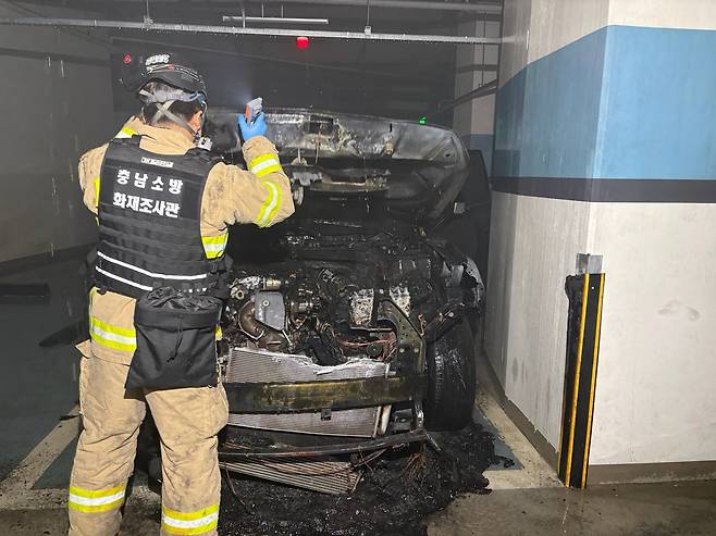 13일 오후 1시 29분쯤 천안시 불당동 한 주상복합 건물 지하 2층 주차장에서 화재가 발새한 SUV를 천안서북소방서 화재조사관이 살펴보고 있다. 천안서북소방서 제공