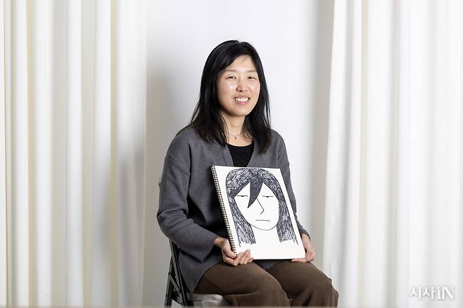 만화가 들개이빨이 <먹는 존재>의 주인공 ‘유양’ 캐릭터를 들고 있다. ⓒ시사IN 박미소