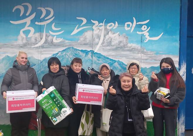 자원봉사자들과 포즈 취한 신조야 대표 (광주=연합뉴스) 박현수 기자 = 11일 광주 고려인마을에서 신조야(오른쪽서 3번째) 대표가 고려인들에게 전달할 기부받은 생필품을 들고 자원봉사자들과 함께 기념 촬영을 하고 있다. 2026. 2. 11. phyeonsoo@yna.co.kr