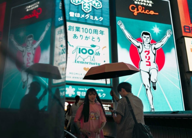 관광명소인 오사카의 일명 ‘글리코’ 간판 앞. EPA 연합뉴스