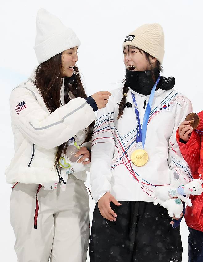 12일(현지시간) 이탈리아 리비뇨 스노파크에서 열린 2026 밀라노·코르티나담페초 동계올림픽 스노보드 여자 하프파이프 결선에서 90.25점을 받아 금메달을 획득한 스노보드 최가온이 은메달을 획득한 미국의 클로이 킴과 기쁨을 나누고 있다./뉴스1