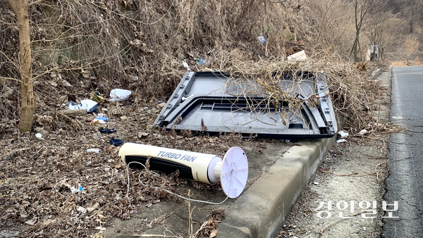 20일 정오께 찾은 화성시 만세구 양감면 덕지산 초입 언덕길. 선풍기와 대형 플라스틱 구조물 등 생활·대형 폐기물이 잡목 지대 곳곳에 버려져 있다. 아래쪽으로는 화성양감산업단지가 자리 잡고 있다. 2026.2.20 /유혜연기자 pi@kyeongin.com