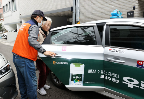 안전한 동행… 언제라도 부르면 부릉부릉 - 2025년 10월 동작구 한 어르신이 효도콜센터 일상생활지원단의 도움을 받아 효도택시에 탑승하고 있다. 동작구 제공