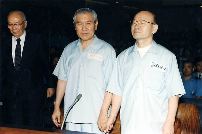 前대통령들 맞잡은 손
역사적인 12.12 및 5.18사건의 1심 선고공판이 열린 26일 오전 서울 서초동 서울지법 417호 대법정에 선 전두환 노태우 두 전직 대통령이 착잡한 표정으로 손을 맞잡고 있다. 〈신문사진공동취재단〉