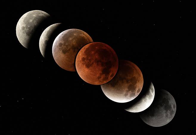 ▲ 경북 영천시 보현산천문과학관에서 올려다본 하늘에서 지구 그림자가 달을 가리는 개기월식이 진행되고 있다. 사진은 개기월식 진행 과정을 보여주기 위해 이날 오전 1시 26분부터 오전 5시 30분까지의 달을 촬영한 사진 7장을 레이어 합성해서 만들었다. 연합