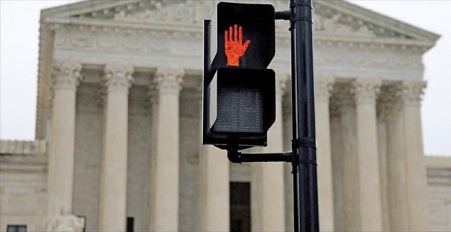 < 美대법, 트럼프 상호관세 ‘정지’ > 미국 워싱턴DC에 있는 연방대법원 앞 신호등에 ‘정지 신호’가 켜져 있다. 대법원은 지난 20일 도널드 트럼프 행정부의 상호관세가 위법이라고 판결했다. 로이터연합뉴스