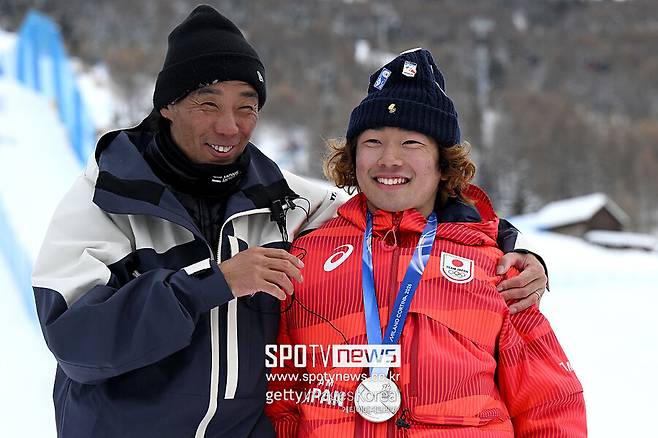 ▲ 이탈리아 리비뇨 스노우 파크에서 열린 2026 밀라노-코르티나 동계 올림픽 12일째 스노보드 슬로프스타일 시상식에서 일본 대표팀의 하세가와 타이가가 코치 사토 야스히로와 함께 기념사진을 찍고 있다.