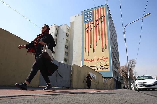 23일(현지시간) 이란 수도 테헤란 시내 건물 외벽에 “미국과 함께 격추돼라”라는 문구와 함께 미사일·해골 등이 그려진 반미 선전 벽보가 그려져 있다. EPA=연합뉴스