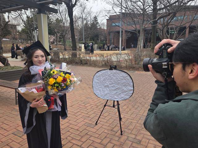 학위복을 차려입은 베트남 유학생 찡이 24일 서울 동대문구 서울시립대 캠퍼스에서 졸업 스냅사진을 촬영하고 있다. 나민서 기자