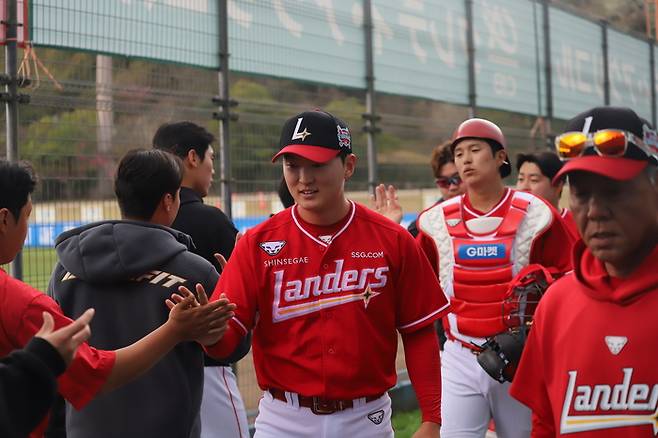 SSG 김건우가 25일 일본 미야자키 아이비 스타디움에서 열린 소프트뱅크와 평가전을 마친 뒤 동료들과 하이파이브를 나누고 있다. 사진 | SSG 랜더스