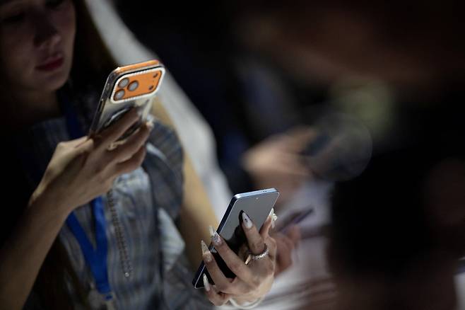 25일(현지시간) 미국 샌프란시스코에서 열린 갤럭시 언팩에서 한 참석자가 갤럭시S26 스마트폰을 살펴보고 있다. /사진=REUTERS