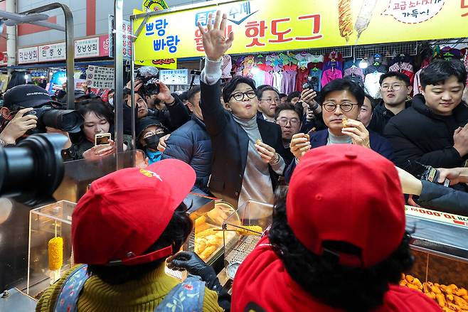 한동훈 국민의힘 전 대표가 2월 27일 오후 대구 서문시장에 도착해 상인들이 건네는 음식을 먹고 있다. 연합뉴스