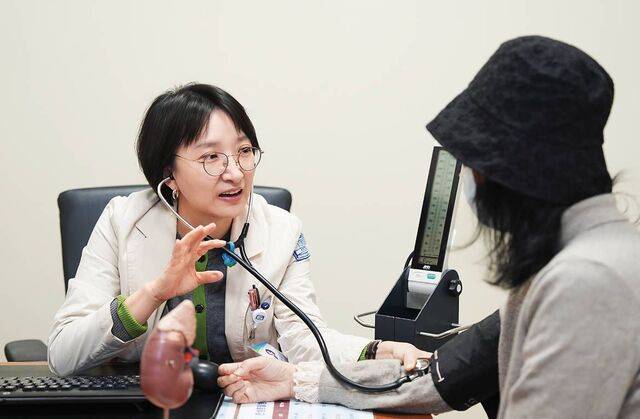 윤혜은 서울성모병원 신장내과 교수가 소변 검사 결과 단백뇨가 의심되는 40대 여성의 혈압을 측정하고 있다.