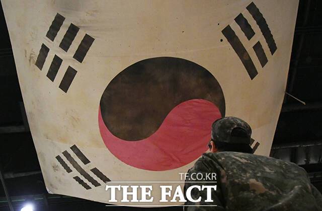 한 육군 장병이 6일 오전 서울 용산구 전쟁기념관 천장에 걸린 태극기를 바라보고 있다. 해당 태극기는 한국전쟁 당시 태극기를 복원한 것이다.