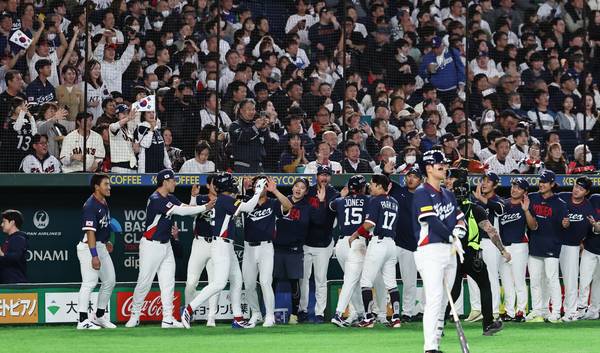 7일 일본 도쿄돔에서 열린 2026 WBC 조별리그 C조 2차전 대한민국과 일본의 경기. 1회초 2사 1, 2루 한국 문보경의 2타점 적시타로 홈을 밟은 이정후와 존스가 동료선수들과 하이파이브를 하고 있다./연합뉴스