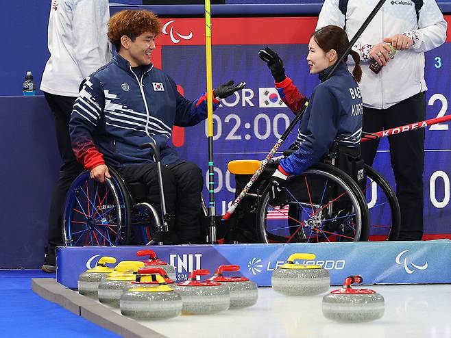 10일(현지시간) 이탈리아 코르티나 컬링 올림픽 스타디움에서 열린 2026 밀라노·코르티나담페초 동계 패럴림픽 휠체어컬링 믹스더블 준결승 대한민국과 미국의 경기에서 6-3으로 승리를 거두고 결승에 진출한 백혜진(오른쪽)-이용석 조(경기도장애인체육회)가 하이파이브를 하고 있다. <연합뉴스>