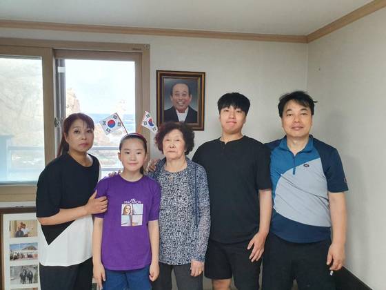 독도의 유일한 주민이었던 김신열(가운데)씨가 경북 울릉군 울릉읍 독도리 서도 주민숙소에서 딸, 사위, 외손자, 손녀와 함께 기념사진을 찍고 있다. 김씨 뒤에는 지난해 숨진 남편 김성도씨 사진이 걸려 있다. 연합뉴스
