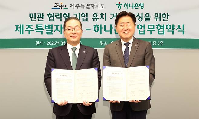 하나은행은 11일 하나은행 제주금융센터지점에서 제주특별자치도와 ‘민·관 협력형 기업 유치 거점 조성’을 위한 업무협약을 체결했다. 이날 협약식에 참석한 이호성 하나은행장(사진 왼쪽)이 오영훈 제주도지사(사진 오른쪽)와 협약서를 들고 기념촬영을 하고 있다./사진=하나은행