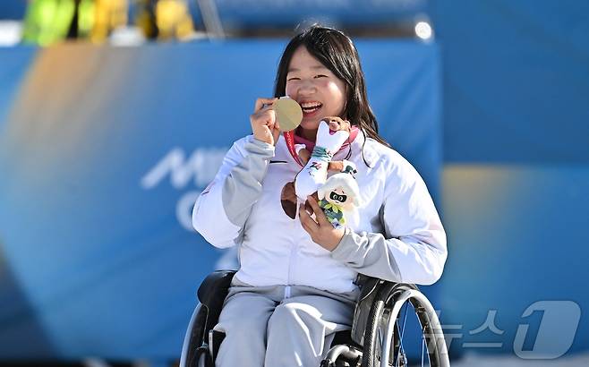 바이애슬론 김윤지가 8일(현지시간) 이탈리아 테세로 크로스컨트리 스키 스타디움에서 열린 2026 밀라노 코르티나 동계패럴림픽 바이애슬론 12.5km 시상식에서 금메달을 깨물고 있다. 2026.3.9 ⓒ 뉴스1 사진공동취재단