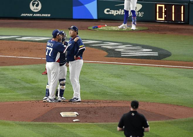 류현진이 2회 위기를 맞자 김광삼 투수코치가 올라가 다독이고 있다. UPI연합뉴스
