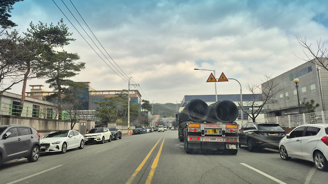 경주 외동 모화산업단지 내부 도로 모습. 공장과 물류 차량이 뒤섞여 다니는 좁은 도로 양옆에 차량들이 주차돼 있다. 산업 기능은 유지되고 있지만 근로자 생활 인프라와 교통 환경은 여전히 취약한 모습이다.<장성재 기자>