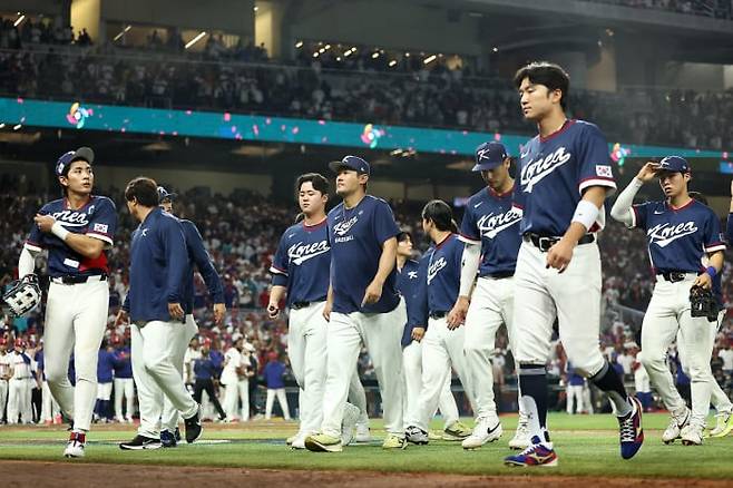 WBC(월드베이스볼클래식) 야구 대표팀 주장 이정후(왼쪽 첫째)를 비롯한 한국 선수들이 14일 미국 마이애미 론디포 파크에서 열린 8강전에서 도미니카공화국에 0대10으로 7회 콜드게임 패배를 당한 뒤 굳은 표정으로 그라운드를 벗어나고 있다. 한국은 이날 9명의 투수를 투입했지만 상대 타자들에게 난타당했고, 타선은 단 2안타에 그쳤다./연합뉴스