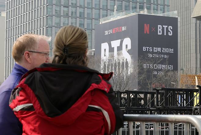 16일 서울 광화문장에서 외국인들이 방탄소년단(BTS)의 컴백 라이브 공연 무대를 설치를 보고 있다. 권욱 기자