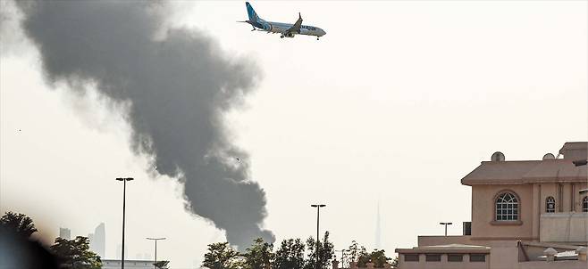 또 공격받은 두바이 공항 16일 이란의 드론 공격으로 연기에 휩싸인 아랍에미리트(UAE) 두바이 국제공항 상공에서 항공기가 착륙을 준비하고 있다. 아랍에미리트는 미국·이스라엘의 공격 이후 주변 국가를 겨냥한 이란의 반격이 집중된 곳이다./AFP 연합뉴스