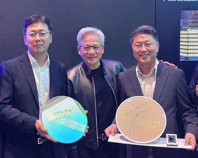 황상준 메모리개발담당 부사장(사진 왼쪽부터), 엔비디아 젠슨 황 최고경영자(CEO), 한진만 파운드리 사업부장 사장이 16일(현지시간) 미국 캘리포니아 새너제이에서 열린 GTC 2026에서 현장에서 삼성전자 부스를 방문해 기념촬영을 하고 있다. 제품은 사진 좌측부터 삼성전자 HBM4 코어다이 웨이퍼와 그록(Groq) LPU 파운드리 4나노 웨이퍼. 각 웨이퍼에는 'AMAZING HBM4'와 'Groq Super FAST'라는 젠슨 황 CEO의 친필 서명이 적혀있다. 삼성전자 제공
