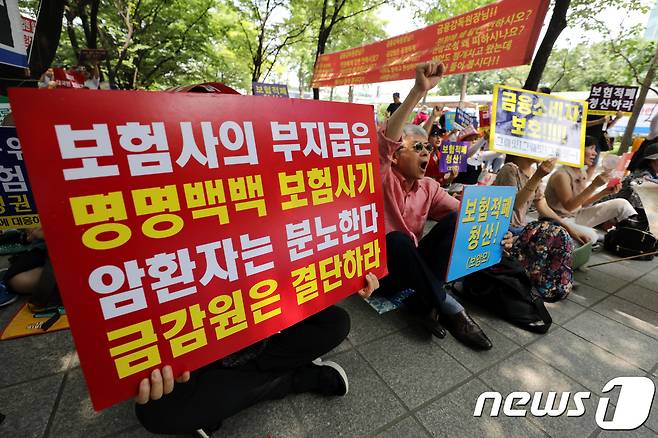 암환자와 가족들로 구성된 보험사에 대응하는 암환우 모임(보암모) 회원들이 2018년 금융감독원 앞에서 보험사의 암입원보험금 부지급 횡포 방임 금감원 규탄 집회를 하고 있는 모습이다. ⓒ 뉴스1 이광호 기자
