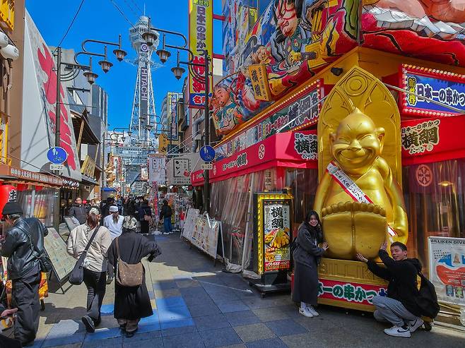 오사카 랜드마크 타워 '츠텐카쿠'와 신세카이의 먹자 골목 풍경. 행운의 신 '빌리켄' 조형물이 포토존 역할을 한다. 백종현 기자