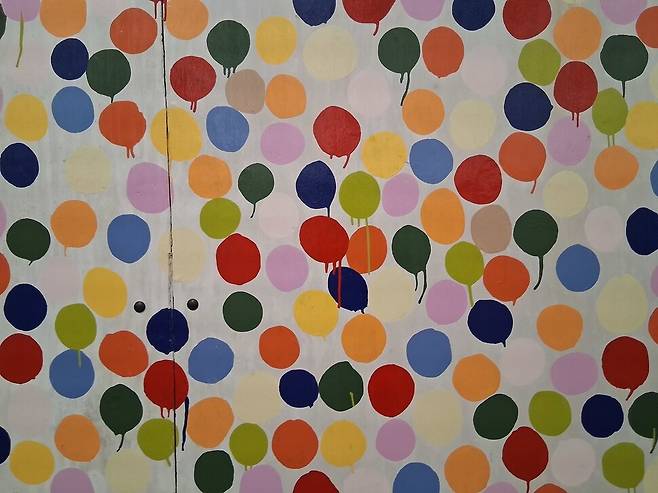 1부 전시장에 나온 허스트의 초창기 색점 그림인 ‘스팟 페인팅’(1986). 싸구려 합판 위에 가정용 페인트로 색점을 그렸는데, 2000년 이후 정연한 스팟 회화와 달리 안료가 아래로 질질 흘러내린 흔적이 보이는 게 특징이다. 노형석 기자